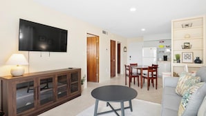 A living room with a TV, a dining table, and a sofa. - Snyder's Rest - A managed by Beach Retreats FL (Bradenton Beach)