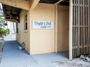 A building with a sign reading 'Snyder's Rest A&B' and a covered outdoor area. - Snyder's Rest - A managed by Beach Retreats FL (Bradenton Beach)