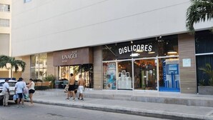 Un edificio que alberga un restaurante de sushi y una tienda llamada DISLICORES.