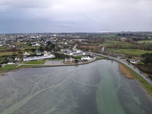 An aerial view of a town with a river, roads, and buildings. - Brand-new, spacious studio apartment for the 2026 season with a view of the bay (Plouescat)