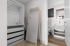 Une salle de bain moderne avec une douche à l’italienne, des toilettes et un espace lavabo.