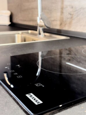 Une plaque de cuisson à induction noire, dotée d’un panneau de commande et portant le nom de marque « FRANKE », clairement visible.
