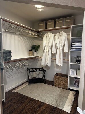 Um closet amplo com cabideiros, prateleiras e caixas organizadoras.