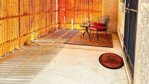 An enclosed patio area with a wooden fence, a metal door, and a table with chairs. - Private Spa Suite + Patio
The Tranquil Corner (Tucson)