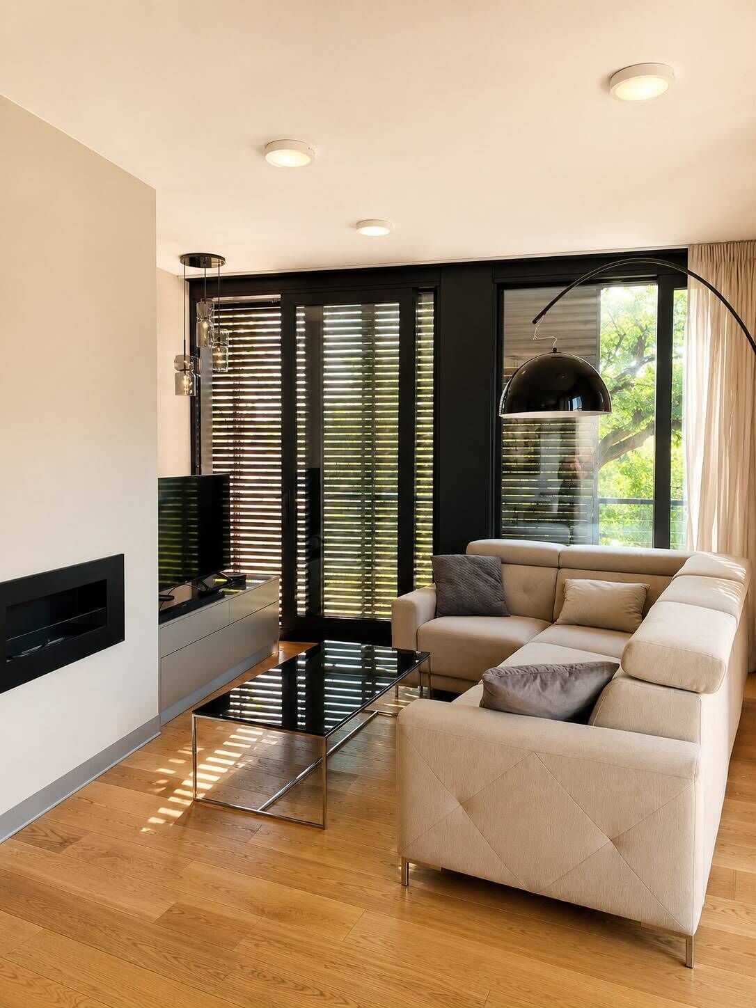 A modern living room with a sofa, a coffee table, and a TV mounted on the wall.