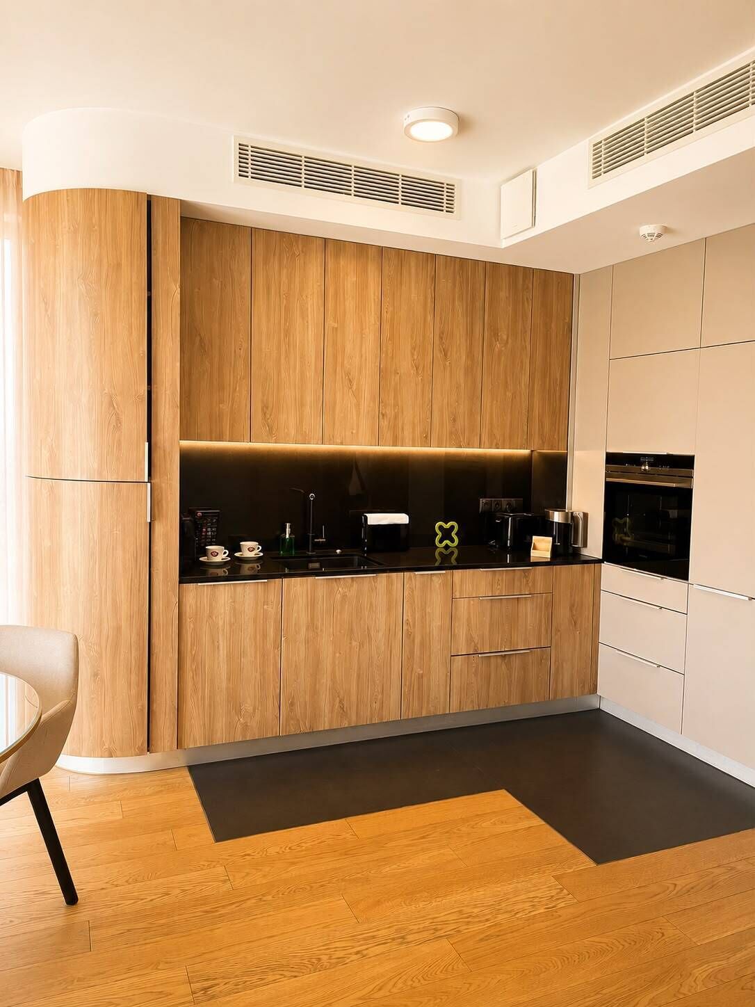 A modern kitchen with wooden cabinetry, a black countertop, and built-in appliances.