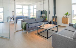 A modern living room with a sofa, coffee table, and a fireplace. - Gorgeous home in Børkop with sauna (Børkop)