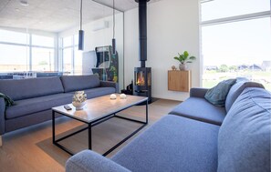 Ein modernes Wohnzimmer mit einer Couch, einem Couchtisch und einem Kaminofen.