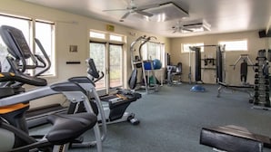 A gym with treadmills, elliptical machines, and weightlifting equipment. - Storm Meadows Retreat | Pool & Hot Tub | Pet Friendly (Steamboat Springs)