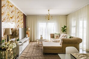 Ein Wohnzimmer mit einer Couch, einem Fernseher und Dekorationselementen.