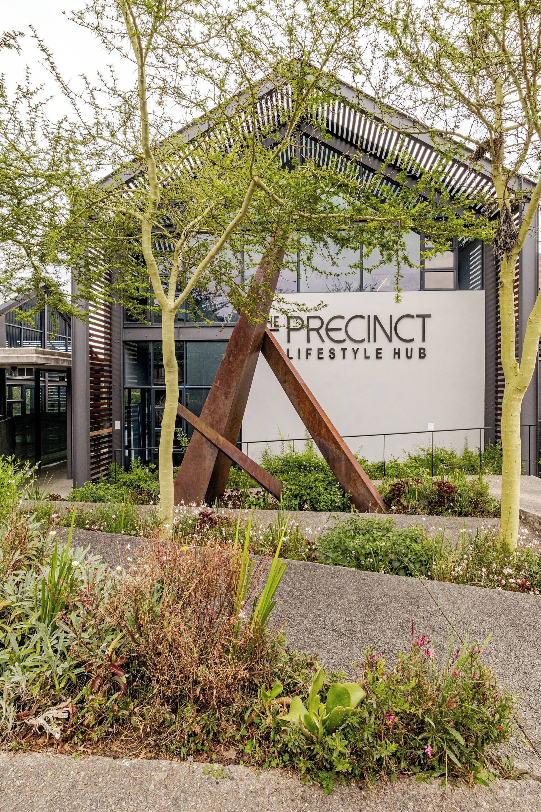A modern building with a sign reading 'The Precinct Lifestyle Hub.'