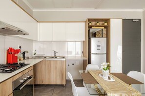 Eine moderne Küche mit Einbauherd, Spüle und Kühlschrank.