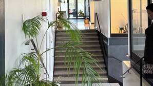 Ein modernes Interieur mit Treppe, hängenden Pendelleuchten und Topfpflanzen.