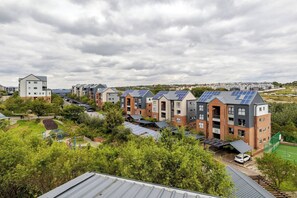 Ein Wohnkomplex mit mehreren Mehrfamilienhäusern, Solaranlagen auf den Dächern und einem Spielplatz.