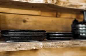 A wooden shelf with stacked black bowls. - Everything, In Montana, All At Once (Saint Regis)