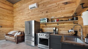 A compact kitchen with a refrigerator, stove, oven, and a coffee maker. - Everything, In Montana, All At Once (Saint Regis)