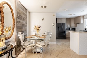A modern kitchen with a built-in refrigerator, a dining area with a glass table and chairs, and a decorative mirror. - 7-Bedroom Ultra-Private Villa Estate •Pool & Gym (Phoenix)