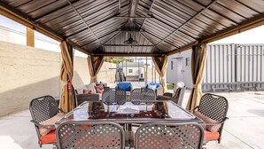 An outdoor patio with a covered seating area, a table, and chairs. - 7-Bedroom Ultra-Private Villa Estate •Pool & Gym (Phoenix)