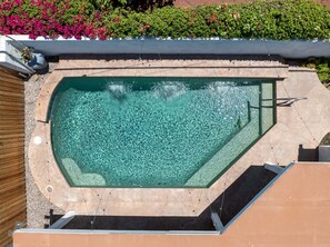 A swimming pool with a clear water surface, surrounded by a wooden deck and a tiled border. - The Cove Villa | 3BR | Private Pool | Sleeps 6 (La Quinta)