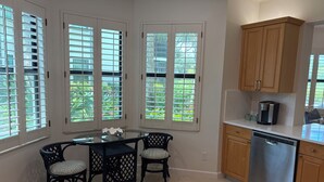 A kitchen with a dining table, chairs, cabinets, and a dishwasher. - Renovated Ravenna first floor townhome in exclusive Pelican Marsh. (Naples)