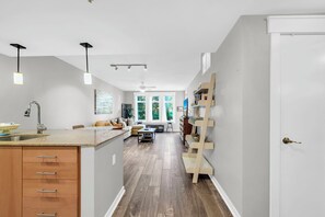 Une cuisine moderne dotée d’un îlot central, d’un coin repas avec une banquette et d’une bibliothèque intégrée.