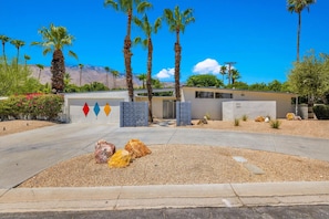 A modern building with a geometric facade, palm trees, and a clear blue sky. - Meiselman Palms - A Ryson Property (Palm Springs)