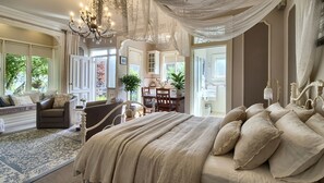 A spacious bedroom with a large bed, a sitting area with a sofa, and a dining area with a table and chairs. - Crofton House and Crofton Cottage @ Port of Echuca BundleHeritage Home (Echuca)