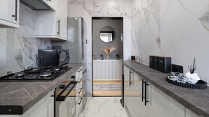 Una cocina moderna con estufa a gas, cafetera y microondas.