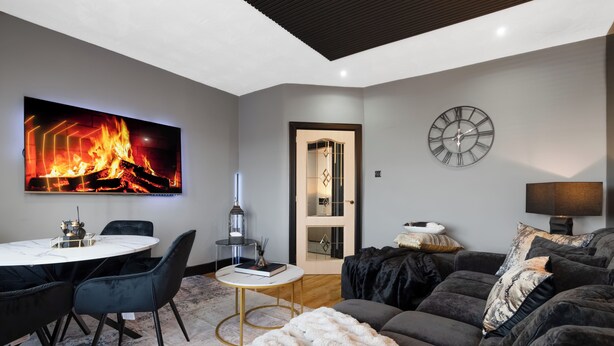 Una sala de estar moderna con chimenea, una mesa redonda y un sofá.