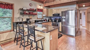 A modern kitchen with a central island, stainless steel appliances, and a wooden ceiling. - Charming 4BR Cabin - HOT TUB - Mountain View (Oakland)