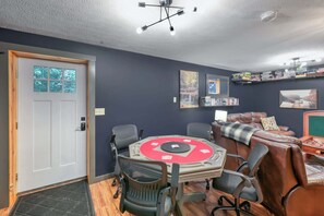 Ein Zimmer mit einem runden Tisch, Stühlen, einer Couch, einem Kamin und einem Bücherregal.
