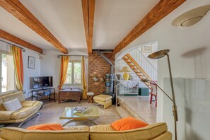 Ein Wohnzimmer mit Fernseher, Sofa, Couchtisch und Kamin.