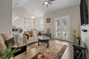 Ein geräumiges Wohnzimmer mit Sofa, Couchtisch und einem Essbereich im Hintergrund.