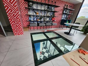 A modern interior with a glass table, a patterned wall, and a bookshelf. - 906 Sky Garden (San José)