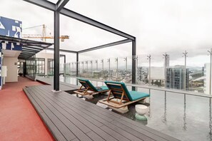 A rooftop terrace with a view of the city, featuring a pool and lounge chairs. - 906 Sky Garden (San José)