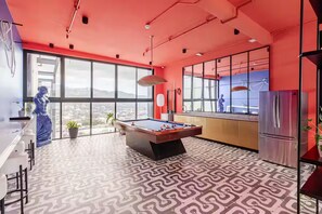 Une cuisine moderne avec un billard, de grandes fenêtres et une vue sur la ville.