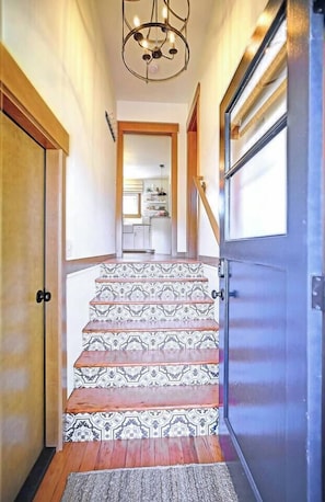 Una escala amb rajoles decoratives que porta a una zona de cuina.