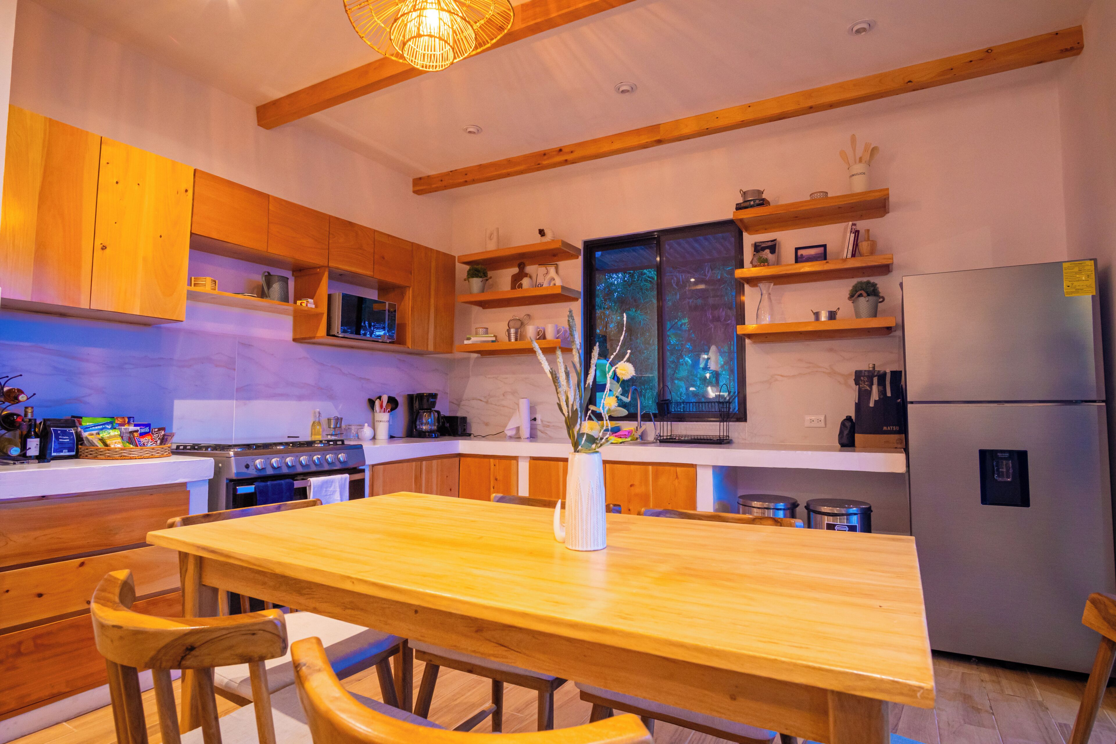 Une cuisine moderne avec des meubles en bois, un îlot central et des appareils électroménagers intégrés.