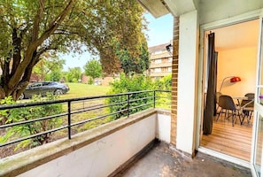 A balcony with a metal railing, a tree, and a parked car in the background. - Family-friendly 2-bed apartment near station, sleeps 5 (London)