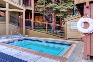 A swimming pool with a lifebuoy, a wooden deck, and a staircase leading to a building. - Walk to Town/ Golf; Pool and Hot Tub (Park City)
