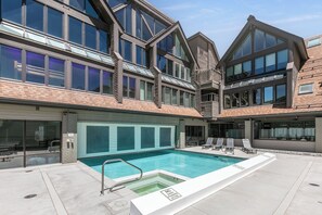 Ein modernes Gebäude mit Schwimmbecken, zahlreichen Fenstern und einer Ziegelaußenwand.