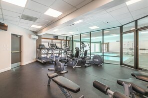Ein Fitnessraum mit Laufbändern, Crosstrainern und Kurzhanteln.