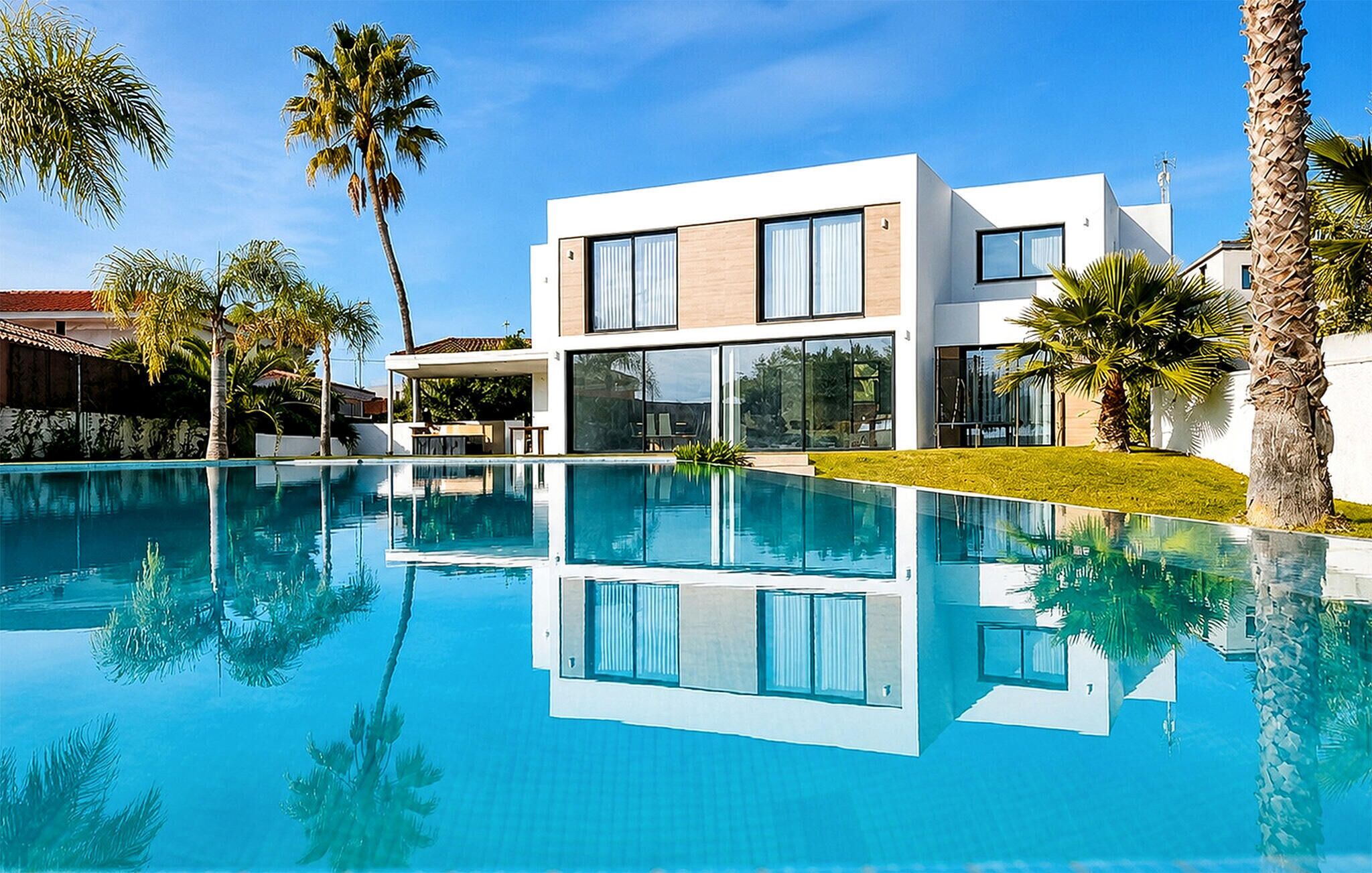 A modern two-story house with a swimming pool in front.