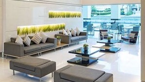 A modern lobby with a sofa set, a coffee table, and a seating area with chairs.