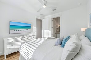 A bedroom with a bed, a TV, a ceiling fan, and a view of the ocean. - Blue Pointe: Private heated pool, Free golf cart, 1min 2 beach, Game & Bunk room (Miramar Beach)