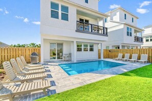 A two-story house with a swimming pool, a patio with lounge chairs, and a wooden fence. - Blue Pointe: Private heated pool, Free golf cart, 1min 2 beach, Game & Bunk room (Miramar Beach)