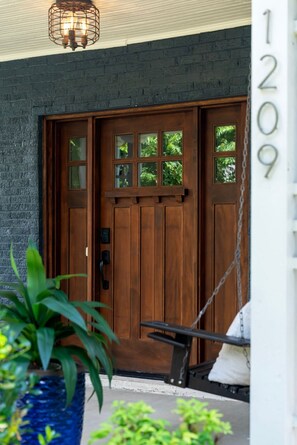 A wooden front door with a number '1209' on the wall to the right. - 🌸 Magnolia House @ 12 South | Private Pool | Sleeps 10 | Fireplace (Nashville)