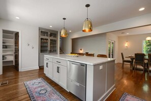 A modern kitchen with a central island, stainless steel appliances, and pendant lighting. - 🌸 Magnolia House @ 12 South | Private Pool | Sleeps 10 | Fireplace (Nashville)