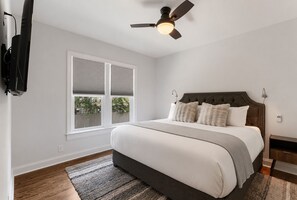 A bedroom with a bed, a ceiling fan, a window with blinds, and a nightstand. - 🌸 Magnolia House @ 12 South | Private Pool | Sleeps 10 | Fireplace (Nashville)