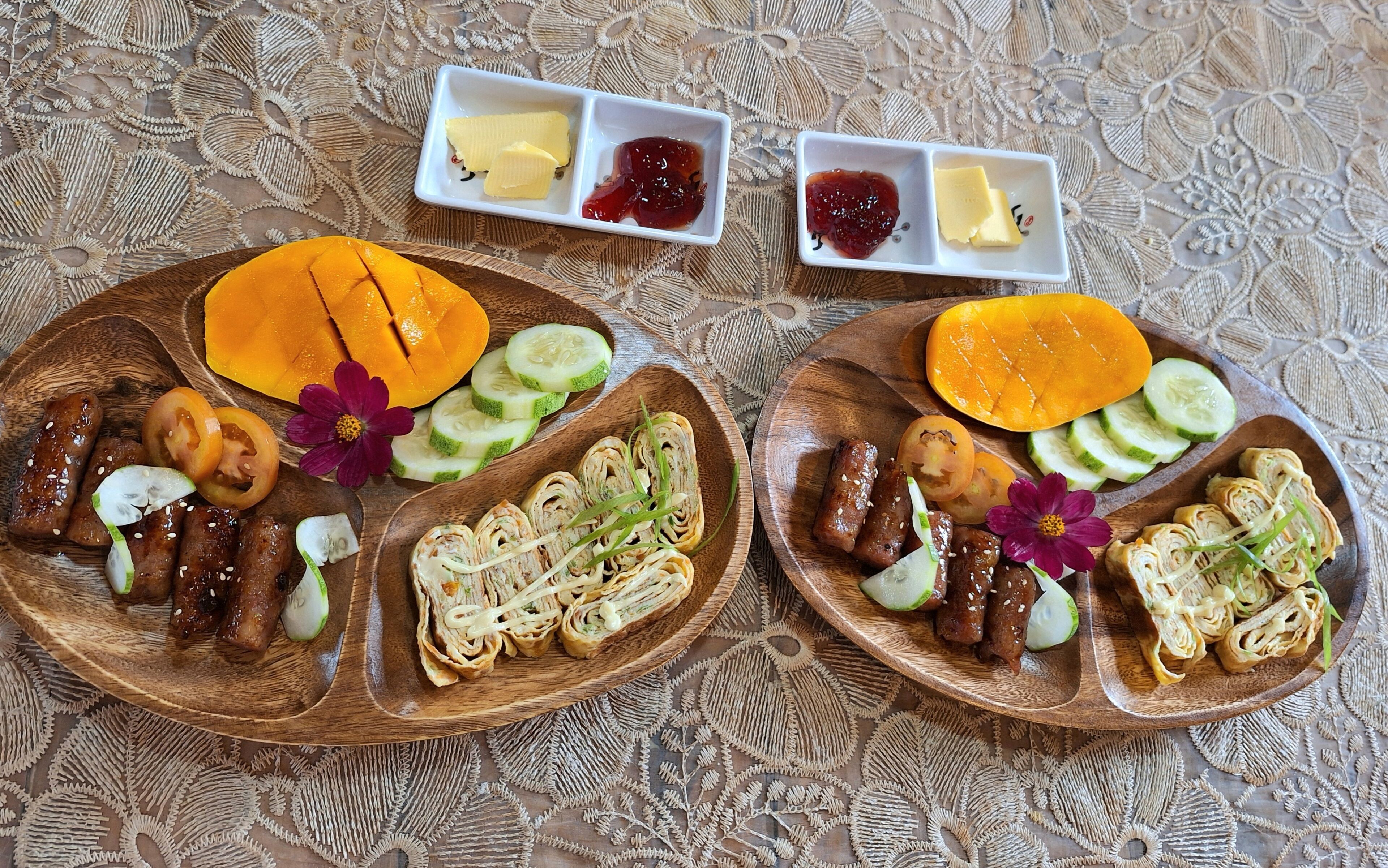 Two wooden plates with food and condiments.